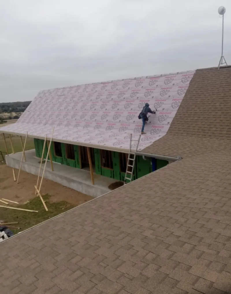 Worker preparing underlayment for a metal roof installation in Reynoldsburg